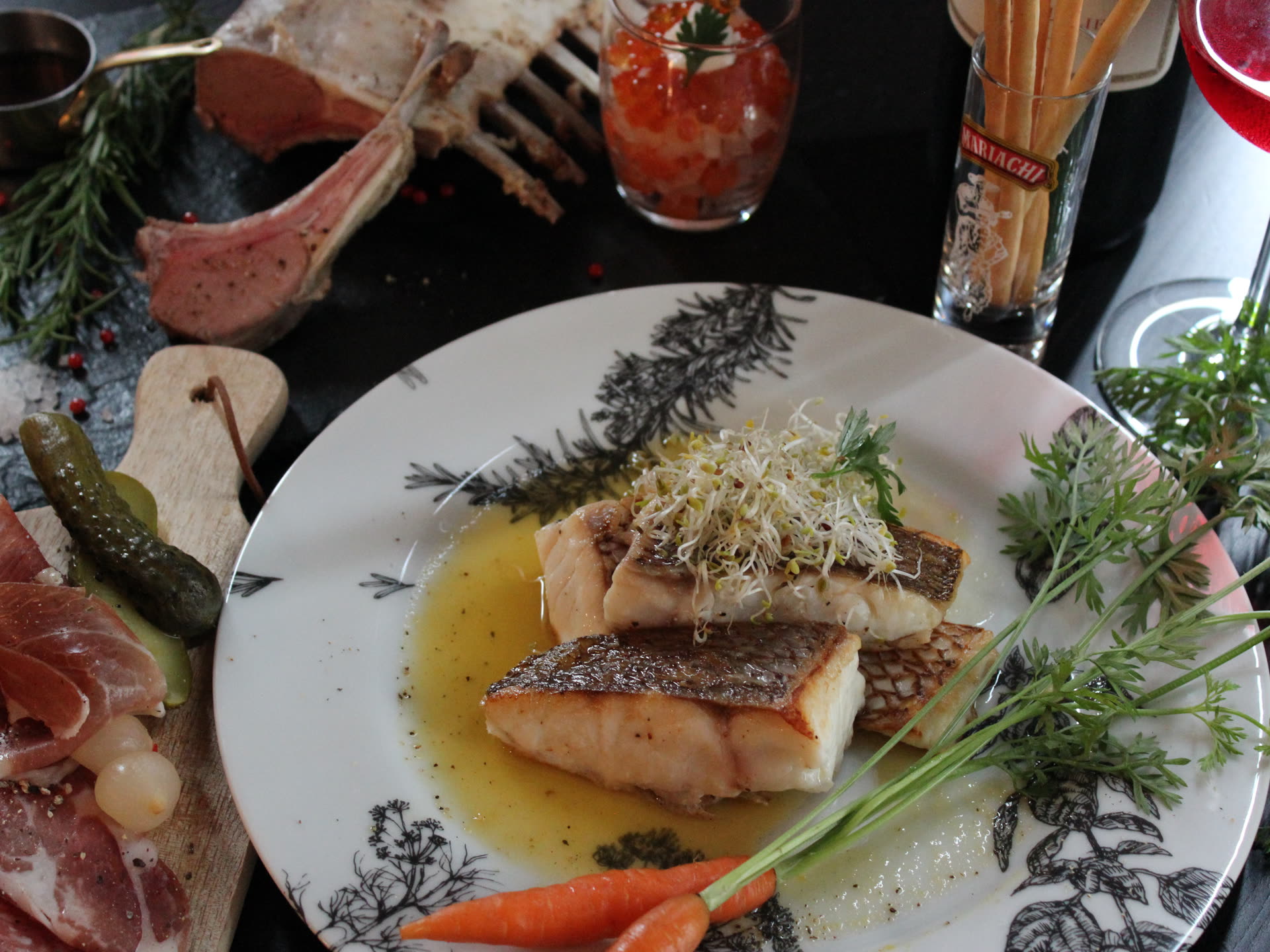 白身魚のポワレを中心にしたビストロ風の一皿。周りにシャルキュトリと野菜